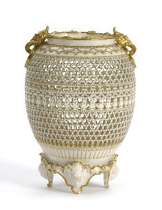 a white and gold vase sitting on top of a table