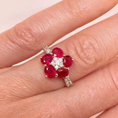 a woman's hand with a red and white ring on top of her finger