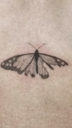 a black and white butterfly tattoo on the chest