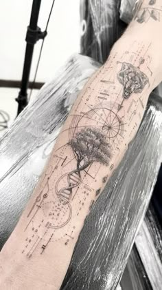 a person with a tattoo on their arm that has an image of a tree in it