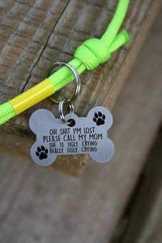 a dog id tag attached to a leash on a piece of wood with a yellow handle