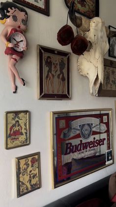 there are many framed pictures on the wall and one has a doll hanging from it