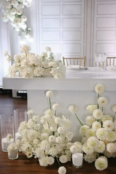 white flowers and candles sit on the table in front of an elegant centerpieces