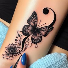 a woman's leg with a butterfly and flower tattoo design on the left side