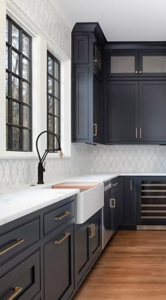 a kitchen with black cabinets and white counter tops