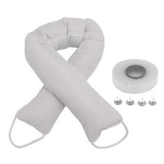 the neck and arm pillow are next to two rolls of fabric with metal fittings