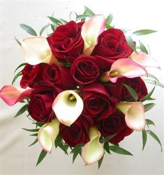 a bouquet of red roses and white calla lilies