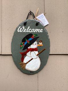 a welcome sign with a snowman holding a broom