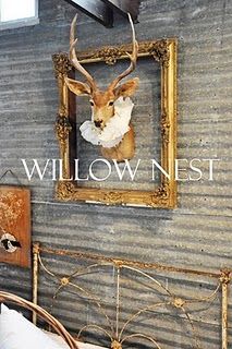 the head of a deer is mounted on the wall next to a metal bed frame