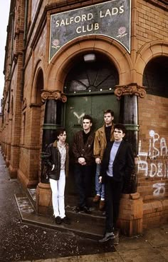 four people standing in the doorway of a building