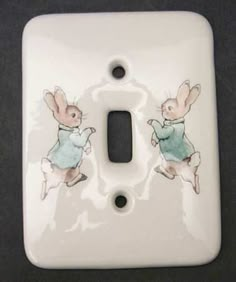 a light switch cover with two rabbits on it