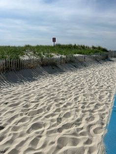 the beach is lined with sand and grass