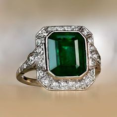 This platinum ring features a high-quality natural emerald cut emerald. Surrounding the center stone is a geometric halo of old European cut diamonds. This ring is made in platinum and has a low profile. ✦ GEMSTONE SPECIFICATIONS: Center Emerald Size: 4.32 Carats Gemstone Cut: Emerald Cut Origin: Zambia ✦ ENGAGEMENT RING SPECIFICATIONS: Ring Material: Platinum Addition Stones: old European cut diamonds ✦ WHAT COMES IN YOUR SHIPMENT: - Your Engagement Ring - Quality Ring Box - Jewelry Cleaner - U Gia Certified Green Emerald Art Deco Ring, Exquisite Green Emerald Ring With Halo Setting, Exquisite Green Emerald Ring, Green Octagon Diamond Ring, Elegant Green Octagon Diamond Ring, Octagon Green Emerald Ring With Center Stone, Art Deco Green Octagon Jewelry, Exquisite Green Emerald Ring For May Birthstone, Emerald Cut Emerald Ring