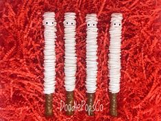 three fake toothbrushes with googly eyes on them sitting on a red carpet