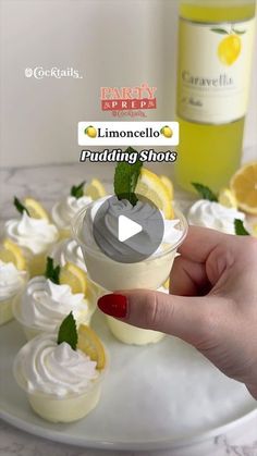 someone holding up a cupcake with lemons and whipped cream