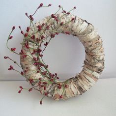 a wreath made out of birch and red berries