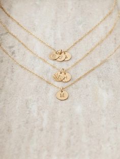 Personalize this 14k gold filled dainty initial disc necklace with a letter, number or symbol. Choose up to 5 tiny gold-filled discs. Each mini disc is hand stamped and you can choose your finish and font style. Charms will overlap each other.  DETAILS  * Tiny gold filled discs measure just 10mm * Gold filled chain, gold filled spring clasp and jump rings * Gold filled is a high-quality long-lasting material, it will not rub off like gold-plating  HOW TO ORDER  * Select your number of Charms/Length and Finish from the drop-down menus on the side and add to cart * Make sure to keep in mind the font you'd like from the photos * Leave your initials/symbols and font choice in the blank text box under the photo at checkout ** REMEMBER: CHOOSE YOUR FONT! **  GOLD FILLED  Gold filled has 100x the Letter Necklace Gold, Initial Disc Necklace, Dainty Initial Necklace, Gold Letter Necklace, Gold Letter, Initial Necklace Gold, Disc Necklace, Gold Letters, Letter Necklace