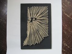 a piece of art made out of sticks on top of a white sheet of paper