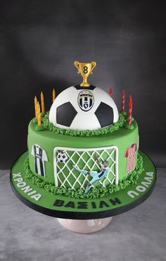 a soccer themed birthday cake with candles and a trophy on top for the ballon d'or winner