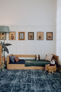 a living room with a couch, lamp and pictures on the wall above it's headboard