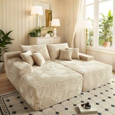 a living room filled with furniture and a large white couch in front of a window