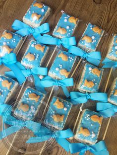 there are many cookies on the table with blue ribbon around them and one has a dog on it