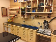 a workbench with lots of drawers and tools on the shelves above it,