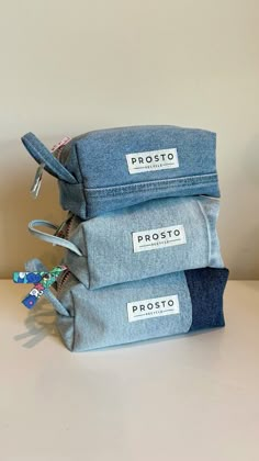 three denim pouches stacked on top of each other with the label prostoo printed on them