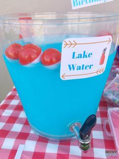 there is a blue ice bucket with water in it and some other items on the table