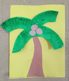 a palm tree made out of paper on a piece of yellow paper with pink dots