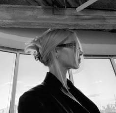 a woman with blonde hair and sunglasses looking out the window