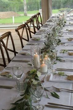 a long table is set up with place settings and candles for dinner guests to enjoy