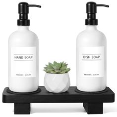 two soap dispensers sitting on a shelf with a succulent in it