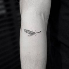 a black and white photo of an eagle tattoo on the arm