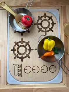 two pans with vegetables on top of a stovetop next to utensils and spoons