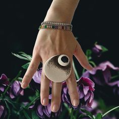 a woman's hand with a bracelet on it and a ring in the middle