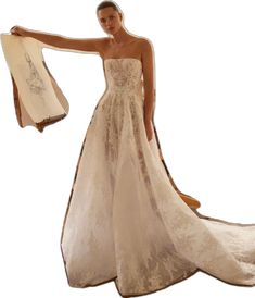 a woman in a wedding dress is holding up a shawl