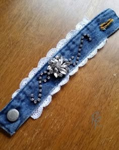 an old pair of jeans with lace and beads on them sitting on a table top