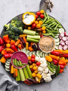 a platter filled with assorted veggies and dip