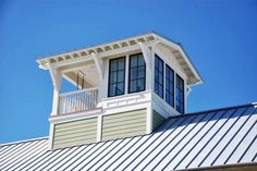 the top of a building with a metal roof and white trim on it's sides