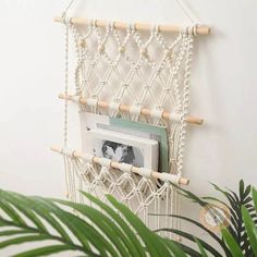 a white macrame hanging on the wall next to a potted green plant