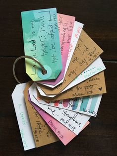 a bunch of tags that are on top of a wooden table with some writing on them