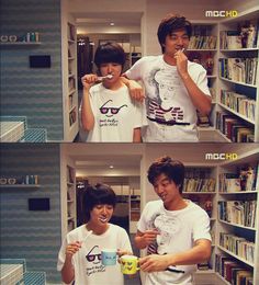 two young men brushing their teeth in front of bookshelves