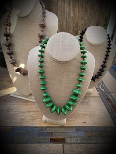 two necklaces are on display in front of a mannequin's head