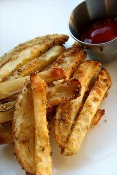 french fries and ketchup on a white plate with a bowl of ketchup