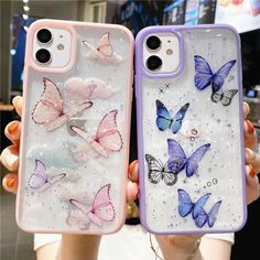 two cases with butterflies painted on them, one is pink and the other is blue