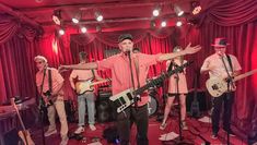 a group of people that are standing in front of some microphones and guitares