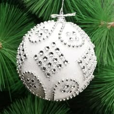 a white ornament hanging from a christmas tree