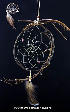 a dream catcher with feathers and beads hanging from it