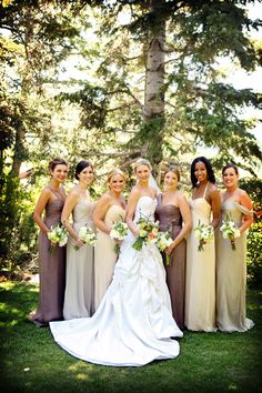 a group of women standing next to each other on top of a lush green field